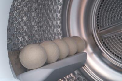  demonstrating how to place dry balls into your laundry.