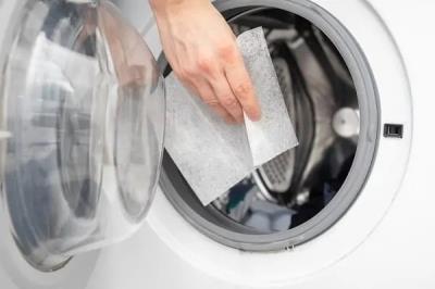 dryer sheet being placed into laundry machine