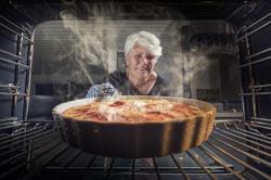 A woman pulling a pie from a Samsung Oven in Phoenix